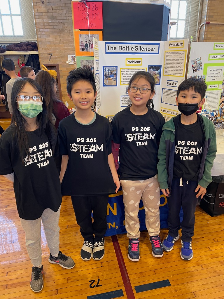 4 students wearing black tshirts with PS 105 STEAM team written in white
